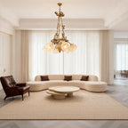 Flower chandelier above a curved sofa in a minimalist living room