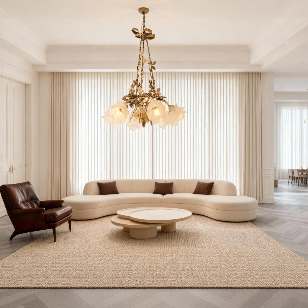 Flower chandelier above a curved sofa in a minimalist living room