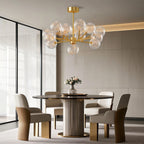 Globe chandelier above a fluted table in a neutral room