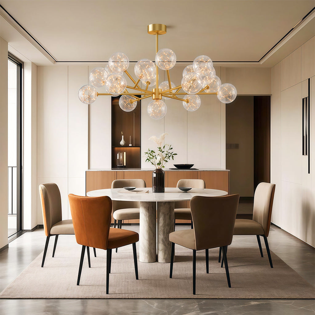 Globe chandelier hanging above warm rust dining chairs