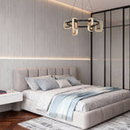 Gold chandelier in a minimalist bedroom with a gray tufted bed