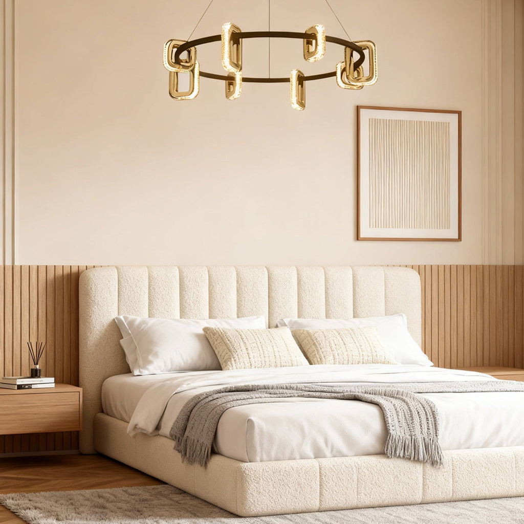 Gold chandelier in an elegant bedroom with a cream tufted bed