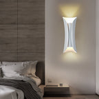 Modern up down wall light beside a bedroom bed