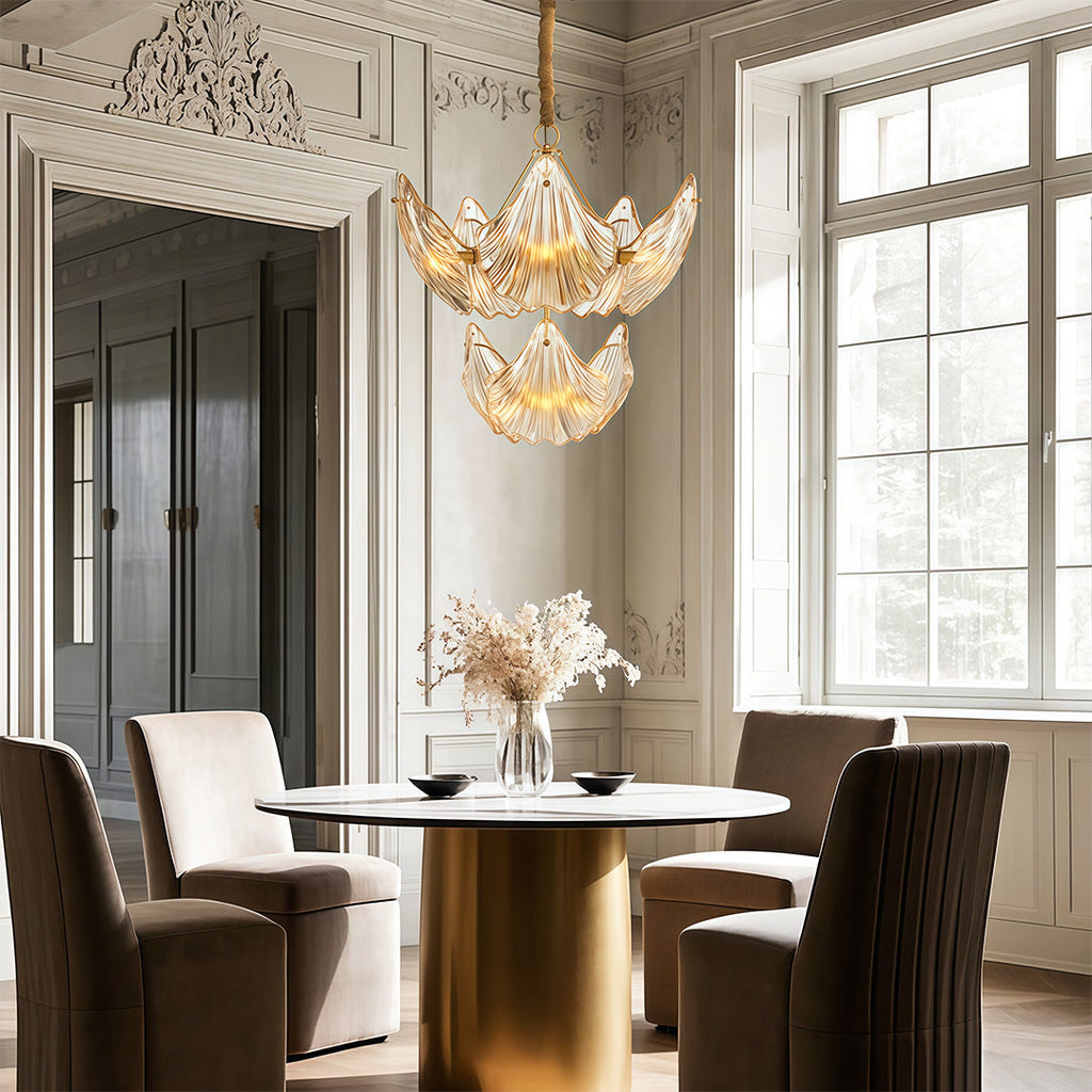 Large chandelier above a brass table with designer chairs
