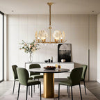 Chandelier above a contemporary dining table with green chairs