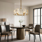 Chandelier above a fluted dining table with designer chairs