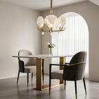 Chandelier above a round table with velvet upholstered chairs
