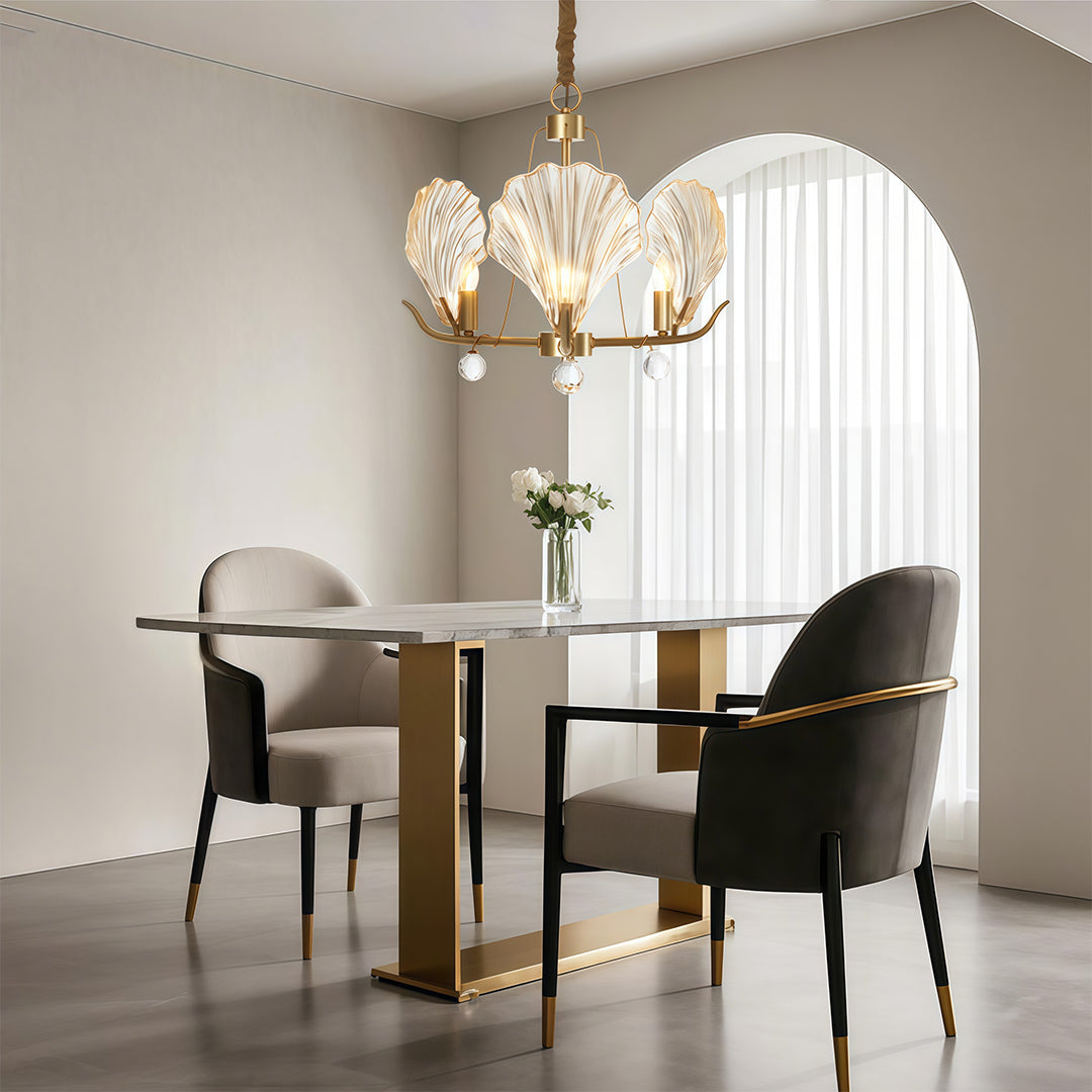 Chandelier above a round table with velvet upholstered chairs