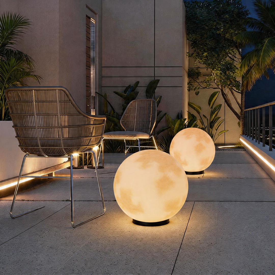 Moon pillar lights on a stone patio beside lounge chairs