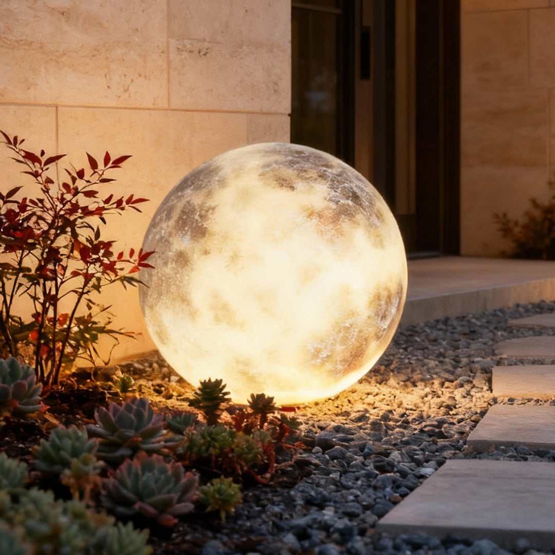 Moon globe light resting on stone ground in a modern yard