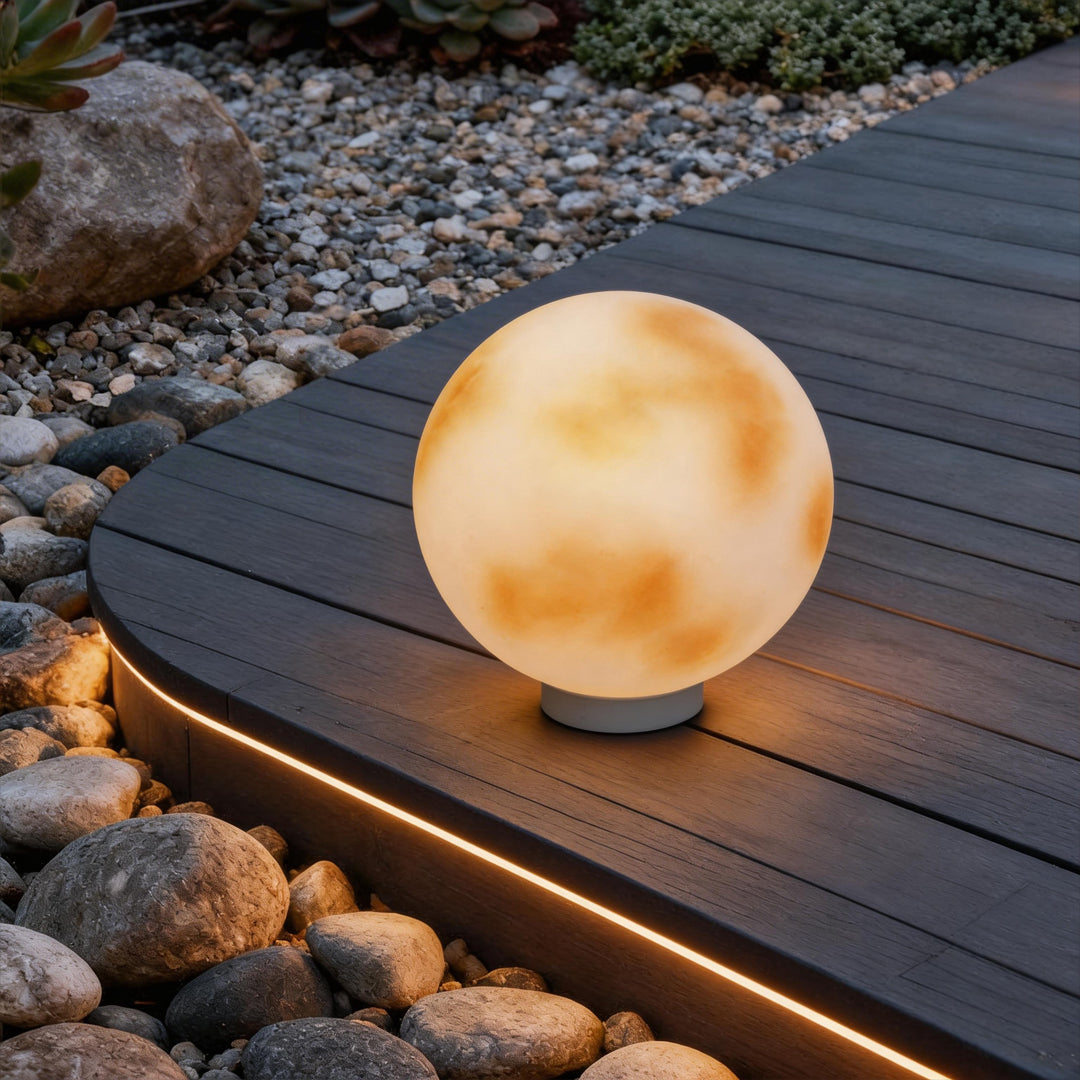 Moon globe pillar light standing on a dark timber deck