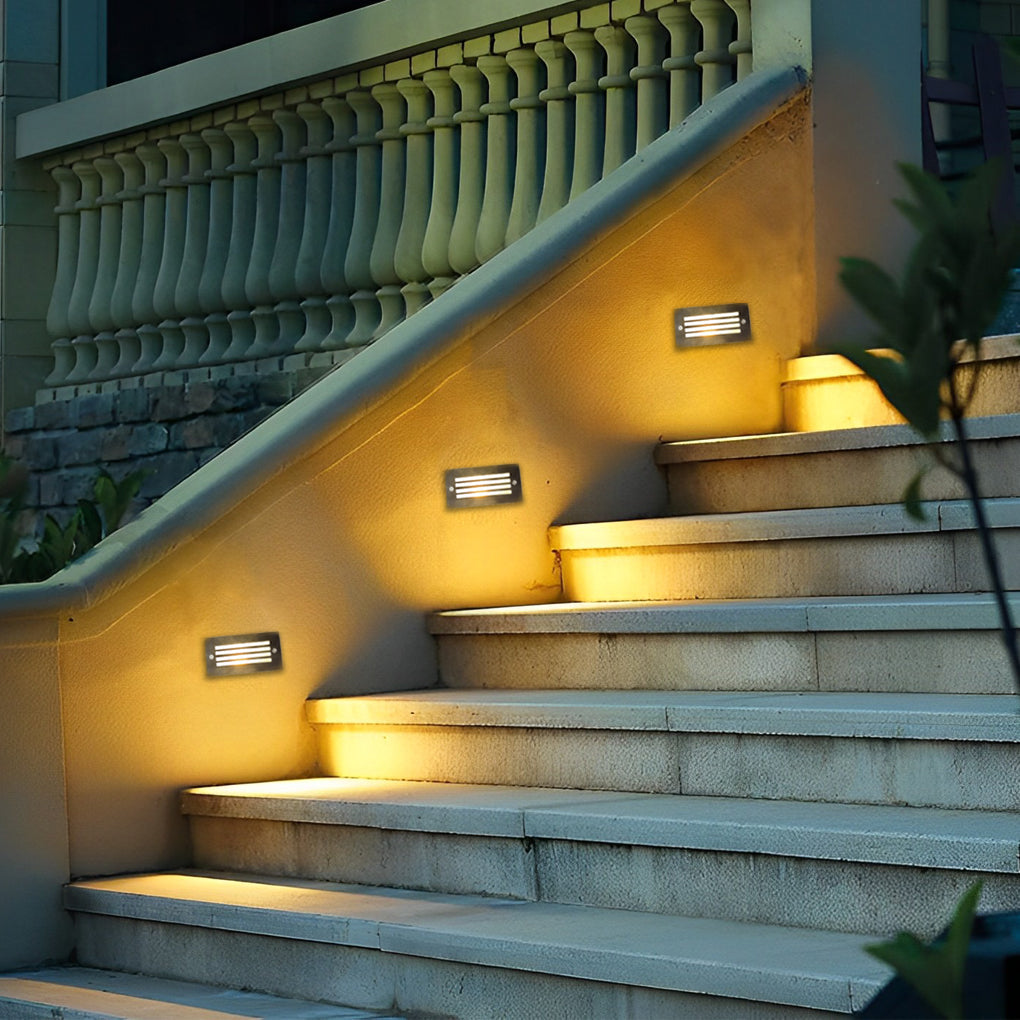 Brick light recessed into a garden patio wall beside a path
