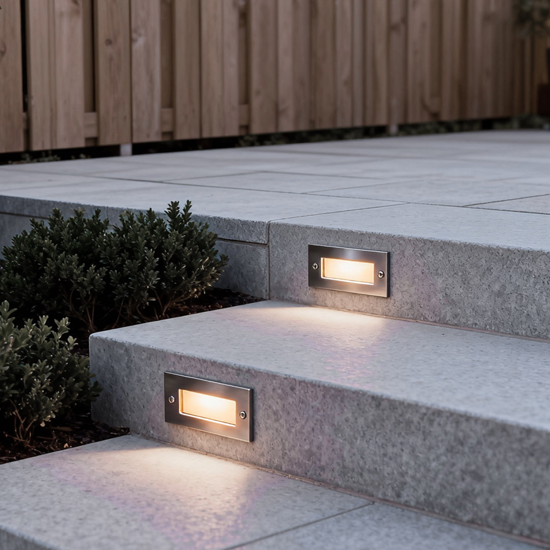 Recessed brick light illuminating the edge of a walkway step