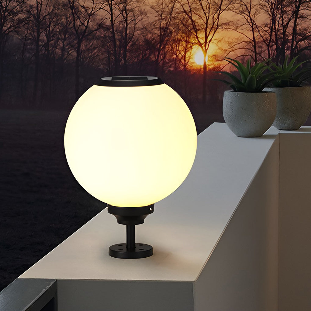 Round pillar light glowing softly against a sunset sky