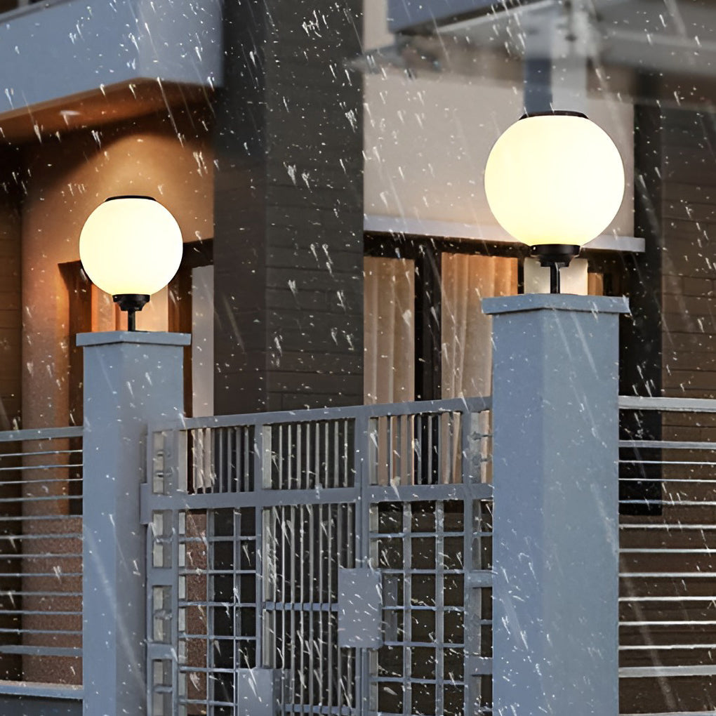 Spherical pillar light shining brightly in a garden at twilight