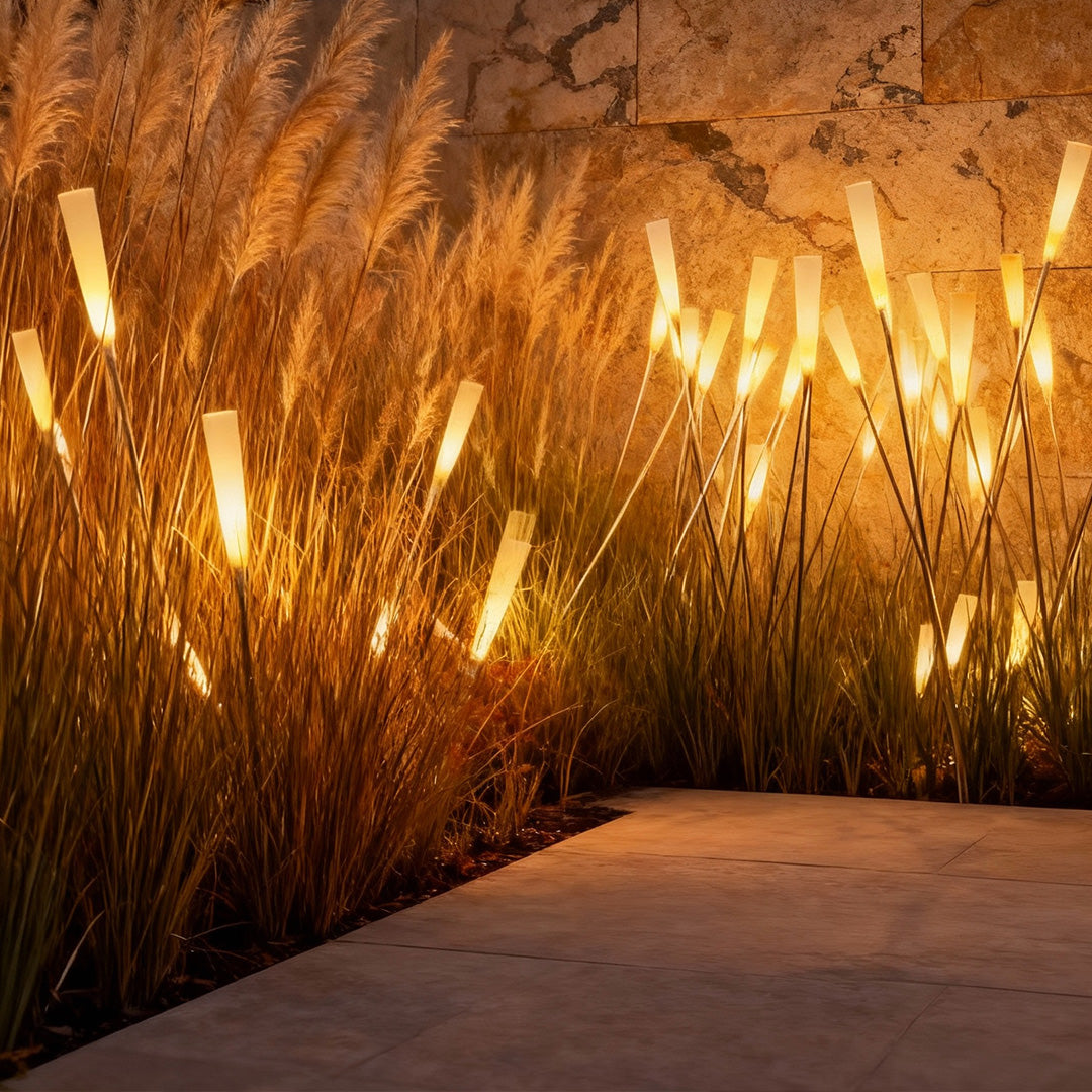 Reed lights glowing warmly along a garden pathway at dusk