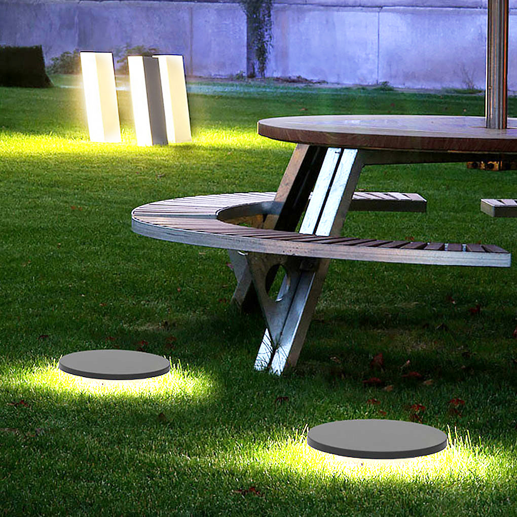 Round lawn light shown installed in backyard grass