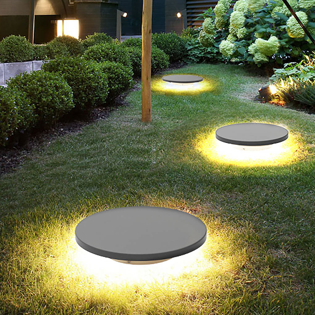 Round lawn light in a garden pathway scene