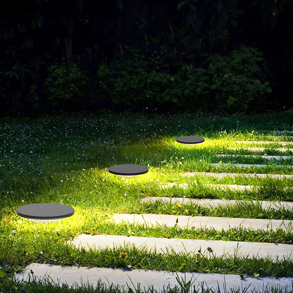 Round lawn light lighting a step and path