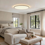 Round flush ceiling light in a neutral toned bedroom