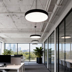 Round pendant lights mounted on an open office ceiling