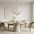 Silver mesh tiered chandelier over a cream oval dining table