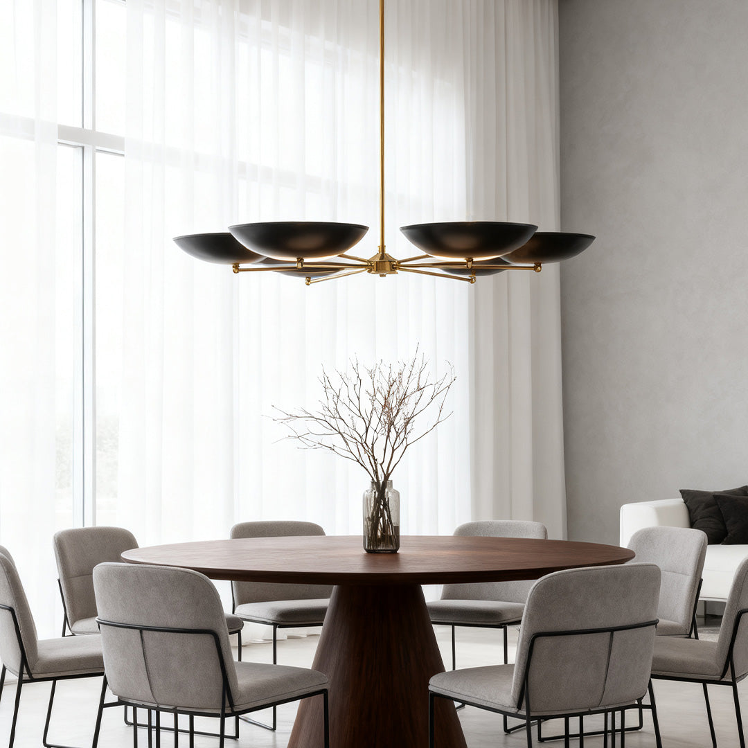 Chandelier above a round wood table in a light-filled room