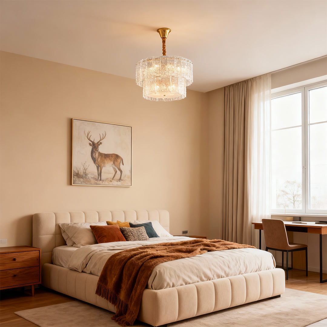Small chandelier above a bedroom with tufted headboard