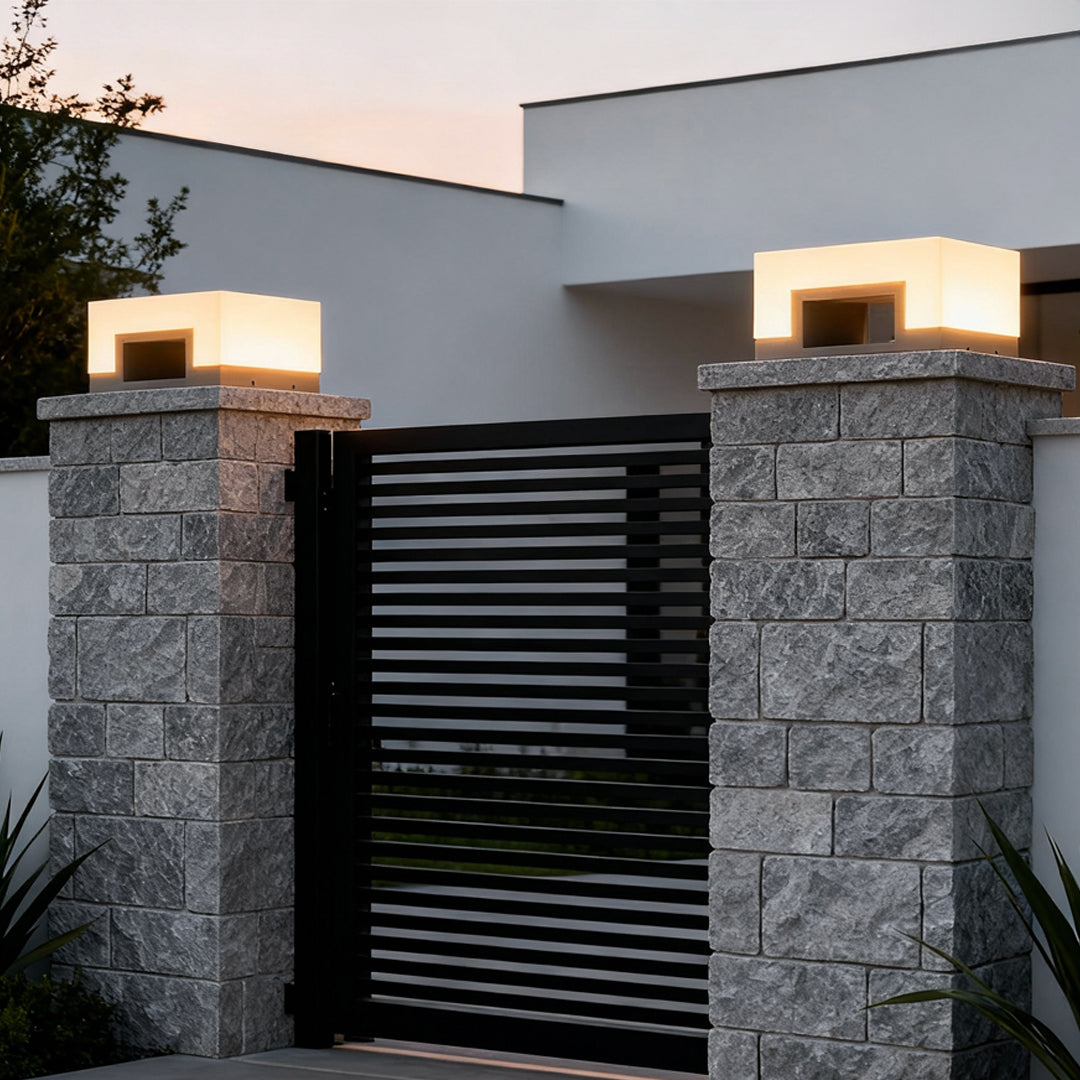 Square solar post lights on stone gate pillars