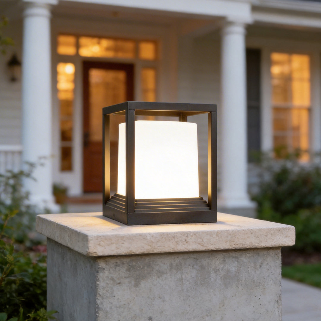 Square black pedestal light on a concrete pillar in daylight