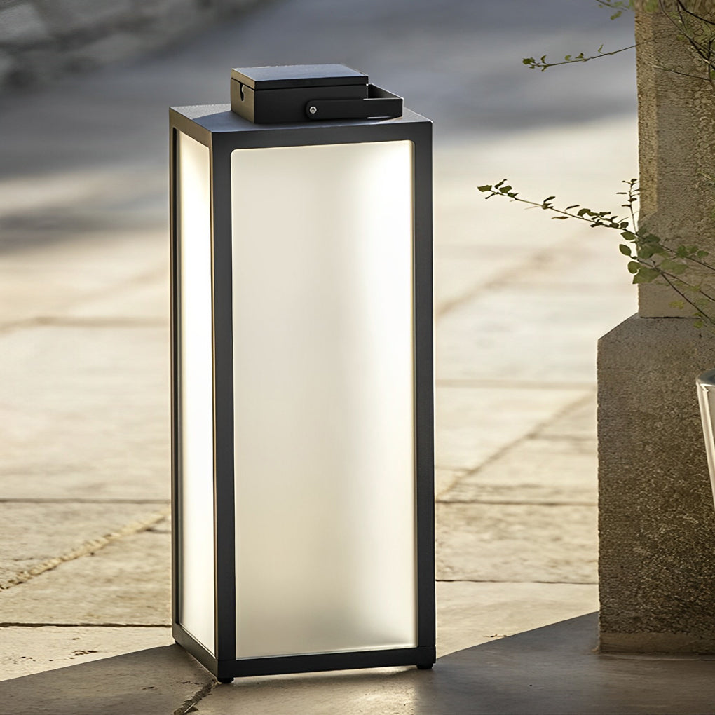 Sleek black framed lantern standing by a tree in a garden