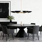 Chandelier above a round black table with plush gray seating
