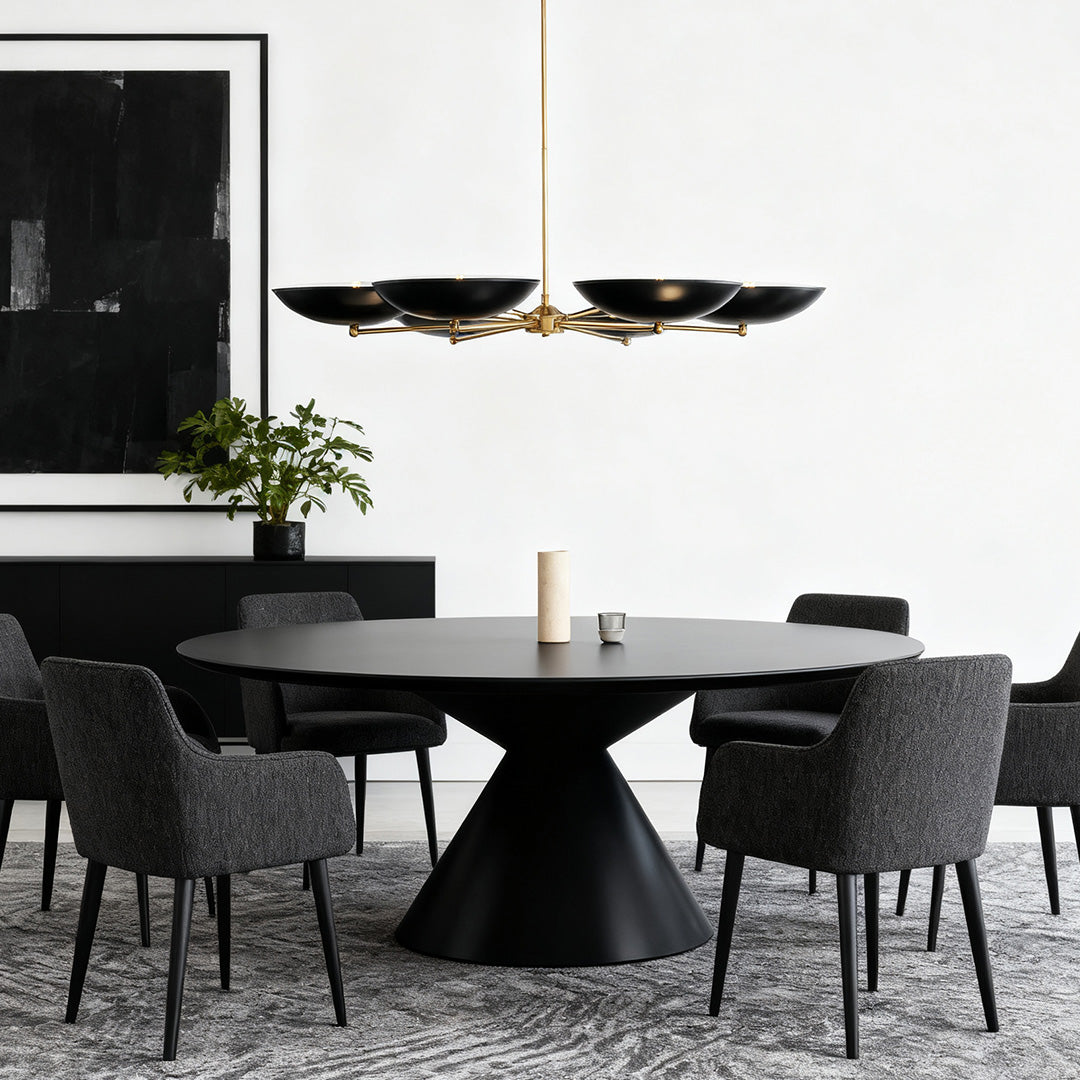 Chandelier above a round black table with plush gray seating