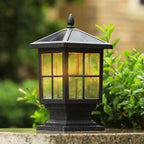 Black lantern lighting a pathway surrounded by greenery