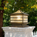 Brass lantern on a concrete post in a garden