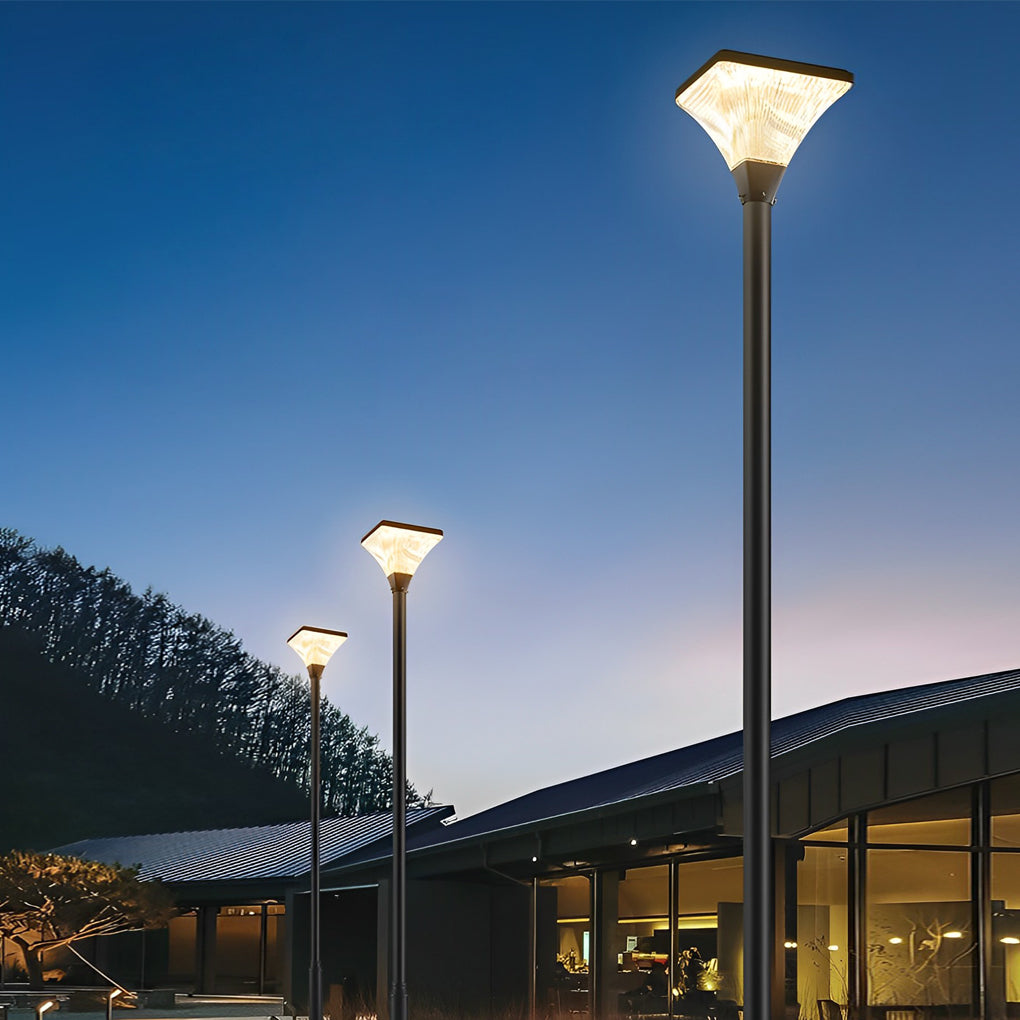 Tall street lights beside a modern building at night