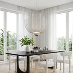 Tiered mesh chandelier above a dark dining table with garden view