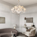 Art glass chandelier in a white living room with a grey sofa