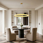 Crystal chandelier above a round table with beige chairs