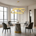 Crystal chandelier above a marble table with black chairs
