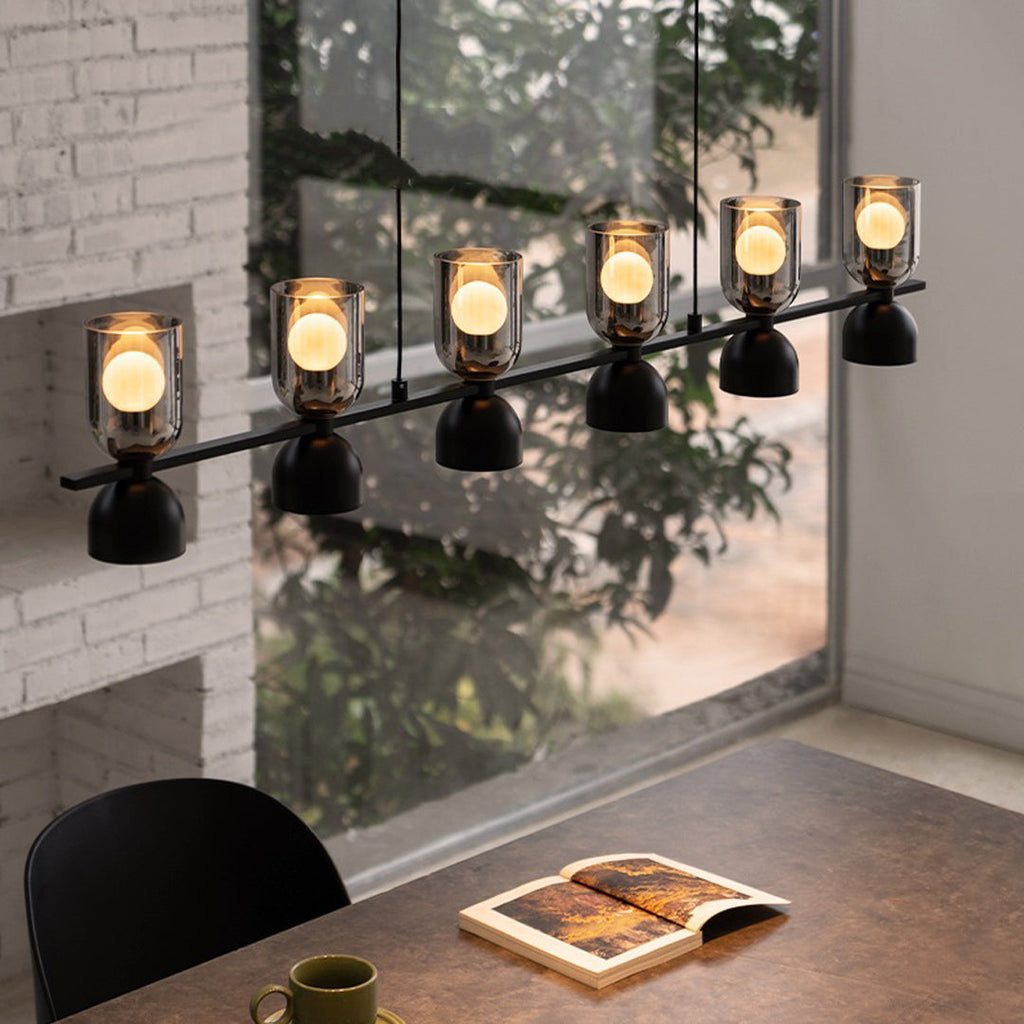 Linear glass pendant chandelier shown against a wall