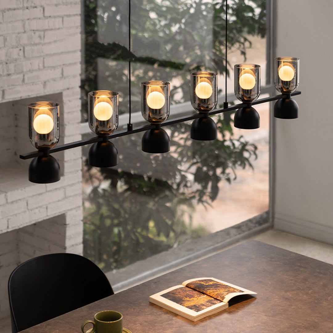 Linear glass pendant chandelier shown against a wall